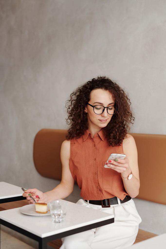 Woman in Orange Tank Top Wearing Black Framed Eyeglasses Sitting on Orange Chair
