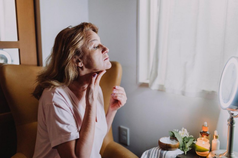 Woman in Pink Button Up Shirt Sitting on Bed