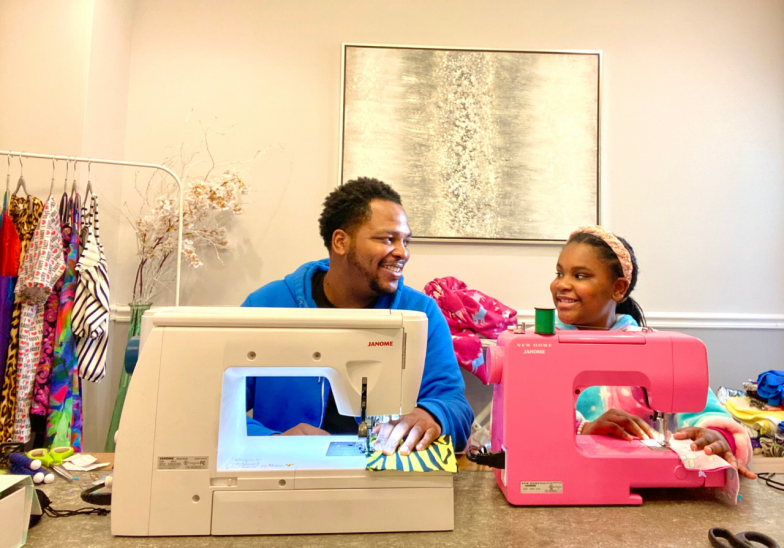 michael gardner using sewing machine with daughter