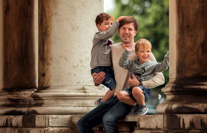 Sergei Urban holding his children outside