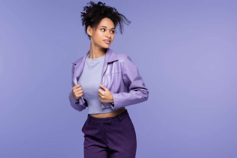 African American woman wearing purple jacket in purple background