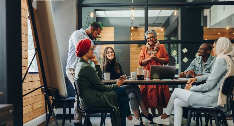 Happy businesspeople smiling cheerfully during a meeting in a creative office. Group of successful business professionals working as a team in a multicultural workplace.