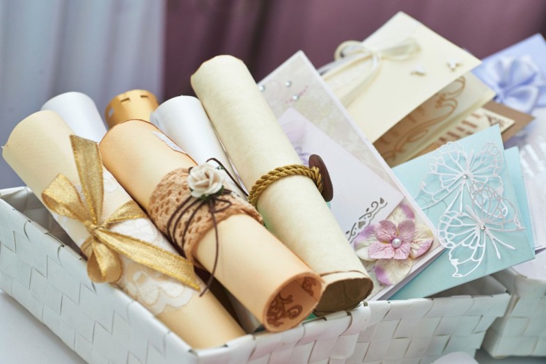 Wedding invitation scrolls in the bucket