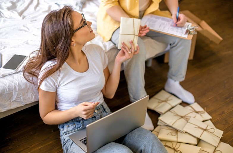 beautiful caucasian married couple sorting letters at home, they plan wedding in future month, going to send invitations to friends and relatives. sit with laptop