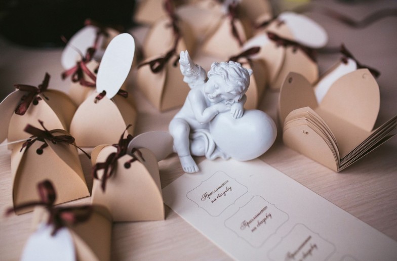 plaster angel with a heart among gift boxes. Wedding decoration. Wedding invitations