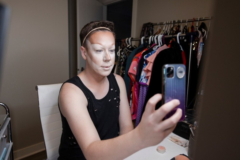 Young male drag queen in makeup getting ready, taking selfie