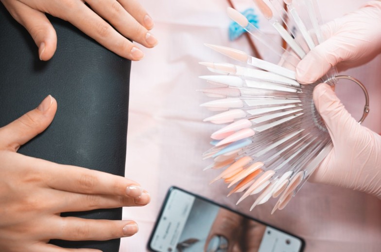 Manicure salon client choosing color of nail polish for manicure from palette colors. Woman getting nail manicure. Professional manicure in beauty salon. Nail art, hands care, beauty industry concept.