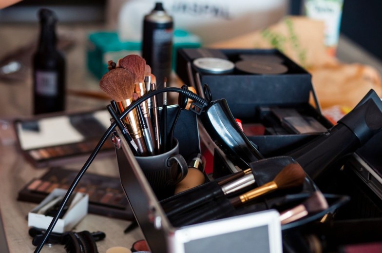 Dedicated focus Make-up converter on makeup artist's table with lots of makeup artist tools. The stack surrounds the makeup artist's table, leaving room for text.