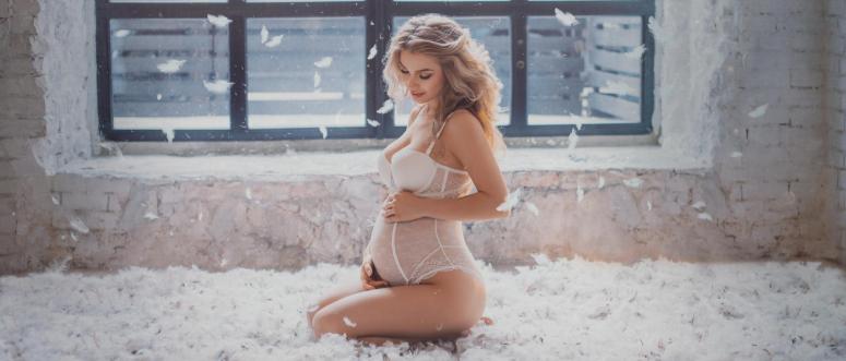 pretty pregnant blond girl in an elegant feminine white underwear surrounded by feathers pretty pregnant blond girl in an elegant feminine white underwear surrounded by feathers
