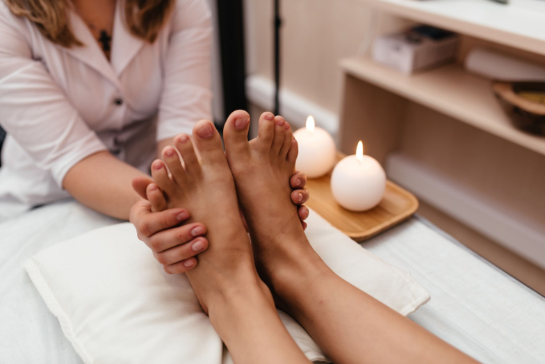 Woman having reflexology foot massage in wellness spa center