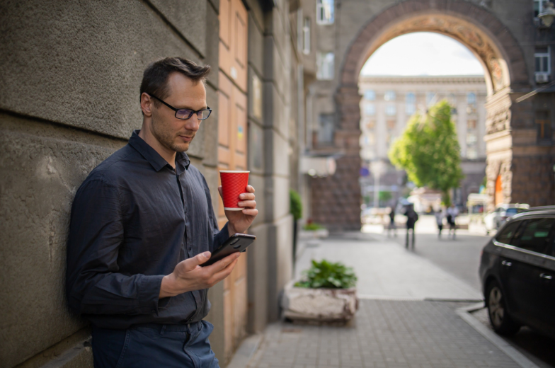 Confident male CEO supervising employees checking financial statements in online database via smart phone