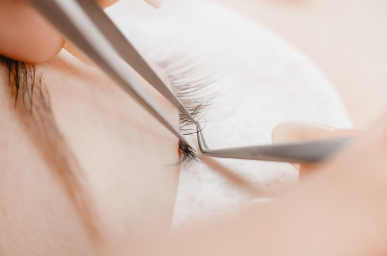 Concept eyelash extension procedure. Macro photo woman with long lashes in beauty salon.