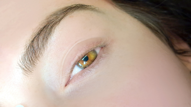 close up of eye with eyelash extensions in beauty salon macro eye top view.