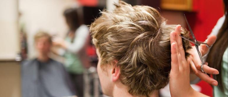 Blond-haired man having a haircut with scissors Blond-haired man having a haircut with scissors