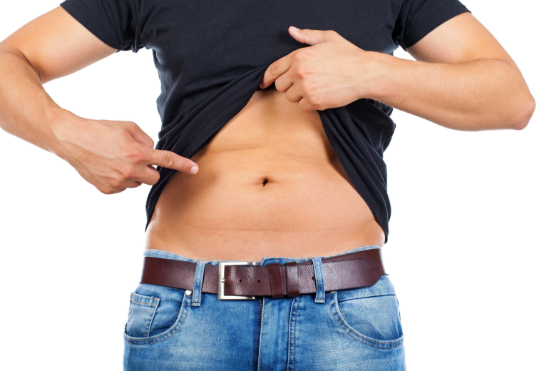 Close up picture of a caucasian young man's fatty abdomen on isolated background