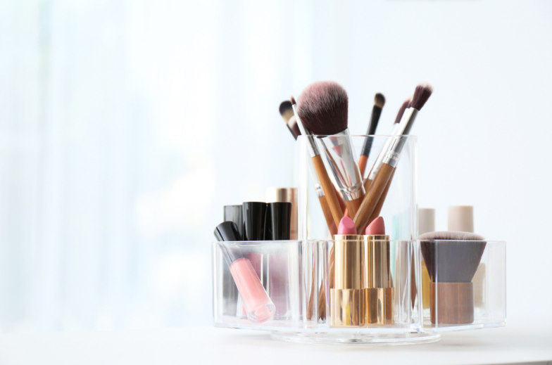 Organizer with makeup cosmetic products on table indoors. Space for text