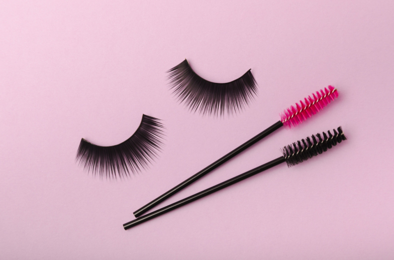Eyelash extension brushes on a lilac background. Brush for combing extended and false eyelashes. Brush for straightening eyelashes and eyebrows.
