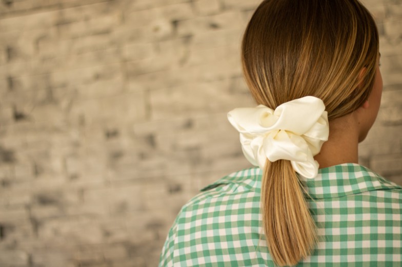 Scrunchies, those nostalgic hair accessories from the '90s, have made a stylish comeback as an essential part of modern hairstyles. Discover the endless possibilities of scrunchy hairstyles that effortlessly blend fashion with function, adding flair to your everyday look.  Introduction to Scrunchy Hairstyles Scrunchies have evolved from their humble beginnings as functional hair ties to trendy fashion statements. They add a playful touch to any hairstyle, whether you're running errands, attending work meetings, or enjoying a night out with friends.  5 Scrunchy hairstyles for everyday wear Elevate your everyday style with these simple and chic scrunchy hairstyles. These hairstyles add a touch of flair to your daily look, perfect for a day at the office, a coffee date with friends, or a casual weekend outing. Let your hair express your personality with these scrunchie-inspired styles that blend comfort and fashion effortlessly.  Messy bun with scrunchie The messy bun with scrunchie is a relaxed and effortless style perfect for casual outings or lazy days at home. Gather your hair into a loose bun on the back or top of your head and secure it with a scrunchie. Allow a few strands to fall loosely around your face to enhance the relaxed vibe.  You can experiment with the placement of the bun, opting for a high bun for a playful look or a low bun for a more relaxed style. Pull out a few strands of hair to frame your face or add texture to the bun for added interest.  Half up, half down with scrunchy. The Half-Up, Half-Down with Scrunchie hairstyle combines the best of both worlds by leaving some hair down while pulling the top half into a ponytail or bun secured with a scrunchie. It offers a versatile and stylish look that works for many occasions.  You can create different variations by experimenting with the placement of the scrunchy and the volume of the half-up part. Add braids or twists to the half-up section for texture and visual interest.  Ponytail with scrunchie The ponytail with scrunchie is a classic and timeless hairstyle that gets a modern twist with the addition of a stylish scrunchie. Simply gather your hair at the desired height and secure it with a scrunchie for an instant dose of charm and personality.  You can opt for a sleek, polished ponytail by smoothing out any bumps and tightly securing the scrunchie. Or go for a more relaxed look by allowing some volume and texture in the ponytail.  Low bun with a scrunchie The low bun with scrunchie is a sophisticated, elegant hairstyle for formal and casual occasions. It involves gathering your hair at the nape of your neck and twisting it into a bun before securing it with a scrunchie.  Add a twist or braid to the bun for extra dimension and visual interest. You can also leave a few strands loose around your face to soften the look and beautifully frame your features.  Braids or twists with scrunchy Incorporating braids or twists with a scrunchie adds a playful and youthful touch to your hairstyle. Whether you opt for a single braid, double braids, or intricate twists, adding a scrunchie adds flair and personality to your look.  Experiment with different braid or twist styles, such as fishtail braids, Dutch braids, or rope twists, to find a look that suits your style and preferences. Use scrunchies in complementary colors or patterns to accentuate the texture and intricacy of your braids or twists.  2 Scrunchy Hairstyles for Work or School Elevate your work or school look with these polished, scrunchy hairstyles. These styles offer a blend of sophistication and comfort, making them perfect for a day at the office or attending class in style. Let your personality shine through while keeping your hair secure and stylish with these scrunchie-inspired looks.  Low ponytail with textured scrunchie Opt for a low ponytail secured with a textured scrunchie for a chic and professional look at work or school. This style is simple yet stylish, keeping your hair out of your face while adding a touch of personality. The textured scrunchy adds dimension to your ponytail, making it suitable for casual and formal settings.  Messy bun with a neutral scrunchie Achieve an effortless and polished look with a messy bun adorned with a neutral scrunchie. This style is perfect for busy mornings when rushing for work or school. The neutral scrunchie adds a subtle accent to your bun while keeping your hair secure and stylish throughout the day.  2 Scrunchy Hairstyles for Special Occasions Make a statement at your next special event with these glamorous scrunchy hairstyles. Whether attending a wedding, formal dinner, or celebratory gathering, these elegant styles elevate your look and make you stand out.  Messy bun with embellished scrunchie Create a romantic and effortless look with a messy bun adorned with an embellished scrunchie. This style exudes charm and sophistication, making it perfect for weddings or cocktail parties. Let your hair fall softly around your face for a whimsical touch that complements any formal outfit.  Half Up Half Down with Floral Scrunchie Add a touch of femininity to your special occasion look with a half-up, half-down style with a floral scrunchie. This versatile style perfectly balances casual and elegant, making it suitable for various occasions. Whether you're attending a garden party or a spring wedding, this hairstyle will leave a lasting impression.  Scrunchy hairstyles for everyone Scrunchy hairstyles offer a versatile and stylish way to accessorize your hair for any occasion, whether it's a day at work, a casual outing with friends, or a special event. From simple low ponytails to elegant messy buns, a scrunchy hairstyle suits every taste and preference.  So, the next time you're looking for a fun and stylish way to update your hairstyle, remember to reach for your favorite scrunchie. With creativity and flair, you can create stunning looks that will turn heads and make a statement wherever you go.  And remember, if you ever need professional hair styling services or beauty expertise, you can always count on MOBILESTYLES to connect you with talented beauty professionals who can bring your vision to life. Discover the magic of scrunchy hairstyles and let your hair take center stage!