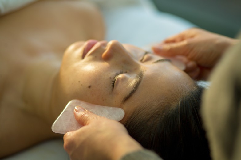 Embark on a transformative journey as we delve deep into the extraordinary benefits of facial gua sha. Rooted in traditional Chinese medicine, this ancient practice has become a cornerstone of modern skincare, offering a harmonious blend of wisdom and radiance. Before we explore the enriching benefits, let's take a moment to understand the basics of this technique and how it has gracefully made its way into today's beauty rituals.  Open HQ8sVr5nLpqS3Xsmd41E2ysjxy39ygZJgGzyFqU5Ybu44itFnASUSGDf3ox6IRiCjFhqPT7gEamBiOobnodGX4lMwah6Yy-FxbuWbCEl89IGROey71X7p2LnRXEqGTC0gHD0TsTxgrphRBZQGU8UarQ HQ8sVr5nLpqS3Xsmd41E2ysjxy39ygZJgGzyFqU5Ybu44itFnASUSGDf3ox6IRiCjFhqPT7gEamBiOobnodGX4lMwah6Yy-FxbuWbCEl89IGROey71X7p2LnRXEqGTC0gHD0TsTxgrphRBZQGU8UarQ Facial Gua Sha Benefits Unveiled Facial Gua Sha is a sacred dance between a smooth-edged tool, often made of jade or rose quartz and your skin. This gentle massage technique has been around for centuries, originally rooted in ancient Chinese medicine. The purpose? To stimulate blood flow, promote lymphatic drainage, and release tension from facial muscles. Think of this practice as a serene melody orchestrating a symphony within your skin, promoting overall health and radiance.  1. Improved circulation and lymphatic drainage The magical strokes of gua sha unlock a world of benefits for your skin's circulation. A study published in the Journal of Alternative and Complementary Medicine found that gua sha significantly increases microcirculation, promoting the efficient delivery of nutrients to skin cells. This increase in blood flow, coupled with lymphatic drainage, not only reduces puffiness, but also facilitates the elimination of toxins, leaving your skin with a radiant, healthy glow.  Unlock Radiance Fact: Gua sha has been shown to increase microcirculation by up to 400%, giving your skin the vibrant boost it craves. 1.  2. Facial contouring and firming effects Beyond the soothing massage, gua sha introduces a unique workout for your facial muscles. The subtle yet effective exercise helps to improve facial contours. According to a clinical study published in Dermatologic Surgery, regular gua sha sessions can result in a noticeable improvement in facial elasticity and firmness, creating a natural lift that reveals a more youthful appearance.  Sculpt Naturally Fact: Gua sha can improve facial firmness by up to 19%, revealing sculpted features with each graceful stroke.  3. Relaxation and Stress Relief Your face bears the weight of daily stress, reflecting tension lines and fatigue. The gentle strokes of gua sha offer more than skin-deep relaxation. A study in the Journal of Physiological Anthropology and Applied Human Science found that gua sha reduces stress hormone levels, contributing to an overall sense of well-being. Think of each stroke as a release of tension, allowing your face to embrace serenity.  Serenity Unveiled Fact: Gua sha has been associated with a remarkable 30% reduction in stress hormone levels, revealing a calm and rejuvenated visage.  4. Natural Detoxification for Vibrant Skin Gua sha's influence goes beyond superficial radiance; it promotes natural detoxification. The rhythmic strokes stimulate the lymphatic system, aiding in the removal of waste and toxins. This detoxifying effect keeps your skin clear and bright, contributing to a complexion that exudes vitality.  Detox Elegance Fact: Regular Gua Sha practice supports the natural detoxification process, promoting vibrant and healthy-looking skin.  5. Enhanced product absorption for optimal results Imagine your skin care products working in harmony with gua sha to enhance their effectiveness. Gua sha not only increases blood circulation, but also creates micro-channels in the skin, optimizing the absorption of your favorite serums and creams. This synergy ensures that your skincare regimen reaches its full potential, leaving you with nourished and radiant skin.  Skincare Synergy Fact: Gua Sha increases product absorption by up to 70%, maximizing the benefits of your favorite skincare products.  Bonus: Gua Sha Rituals for Daily Radiance Elevate your skincare routine with these Gua Sha rituals that add an extra layer of indulgence to your daily beauty routine:  Morning Energizer: Start your day with gentle upward strokes to awaken your complexion and reduce morning puffiness.  Evening Relaxation: Wind down in the evening with slow, soothing strokes to release tension and promote relaxation before bedtime.  Product Boost: Pair Gua Sha with your favorite facial oil or serum to enhance product absorption and maximize benefits.  Weekly Intensive Session: Dedicate one day a week to an extended gua sha session and treat your skin to a spa-like experience.  Incorporating Gua Sha into Your Beauty Ritual At MOBILESTYLES, we champion the art of personalized self-care. Download our app today to connect with skilled beauty professionals who can guide you on a journey to radiant and rejuvenated skin. Let the ancient secrets of gua sha merge with the convenience of modern technology for a beauty experience uniquely designed for you.  The benefits of gua sha go far beyond the surface, empowering you to embrace your unique beauty and fostering a connection between the ancient traditions of skincare and the contemporary celebration of self-love.