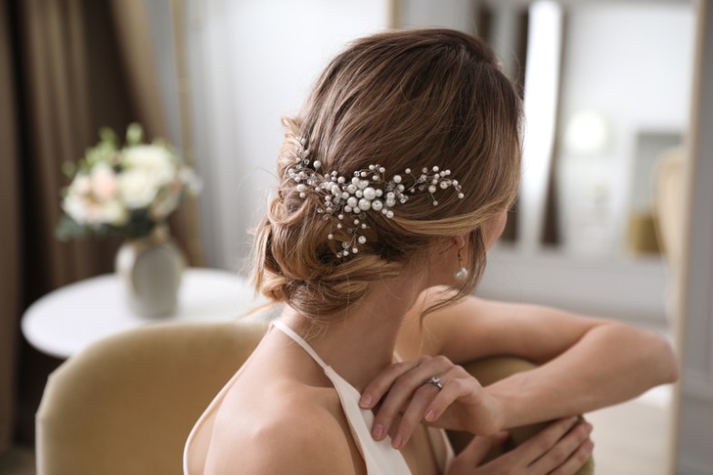 Your wedding day is a celebration of love, and your hair should be as special as the occasion. Discover the magic of beautiful wedding hairstyles that will make you feel like the belle of the ball. Whether you're looking for a romantic updo, a boho braid, classic Hollywood waves, or an elegant low bun, we've got you covered.  Your hair is your crowning glory, and on your wedding day, you deserve a style that reflects your personality and enhances your bridal beauty. Let's dive into these stunning wedding hairstyles to find the perfect one for your dream day.  1. Romantic Updo Timeless and versatile, the romantic updo is a classic choice that fits a variety of wedding themes. It effortlessly combines elegance with a touch of modern romance.  Prep Your Hair: Start by prepping your hair with the right products to add texture and hold.  Create loose curls: Use a curling iron to create loose, cascading curls.  Gather into a low bun: Gather the curls into a low bun, leaving a few strands loose for a soft, romantic touch.  Secure and Finish: Secure the updo with pins and finish with a mist of hairspray for hold.  Styling Tips  Finish the look with delicate hair accessories for a touch of sparkle.  Consider face-framing tendrils for a softer, more whimsical look.  Your wedding day is all about timeless moments, and the romantic updo ensures you'll look back on your photos with delight.  2. Boho Braided Crown Embrace a carefree and bohemian vibe with the Boho Braided Crown. This ethereal style is perfect for outdoor or rustic weddings.  Center part: Part your hair down the middle to create two even sections.  Loose Braids: Create two loose braids on each side, making sure they are not too tight.  Create the crown: Cross the braids over your head and secure them in a crown shape with pins.  Loose strands: Allow a few loose strands to frame your face for an effortless finish.  Styling Tips  Incorporate flowers or greenery into the braids for a boho-chic touch.  Enhance the texture with a touch of sea salt spray for a relaxed, beachy feel.  The boho braid is not just a hairstyle; it's a statement that says, "I'm here to celebrate love in style.  3. Classic Hollywood Waves Step into the glamour of the silver screen with classic Hollywood waves. This sophisticated style is the epitome of timeless elegance, perfect for formal and black-tie weddings.  Voluminous waves: Use a large barrel curling iron to create voluminous waves that cascade gracefully.  Brush for softness: Brush through curls to create soft, flowing waves that evoke old Hollywood glamour.  Side part: Part the hair on the side for a classic Hollywood look.  Finishing Touch: Finish the look with a mist of hairspray to hold the waves in place.  Styling Tips  Opt for a deep side part to add an extra dose of drama to your bridal look.  Use a shiny serum for a shiny, polished finish.  Classic Hollywood waves aren't just a hairstyle; they're a nod to the timeless beauty of iconic movie stars.  4. Elegant low bun For a polished and sophisticated bridal look, the elegant low bun is a timeless choice that complements a variety of face shapes and bridal gown styles.  Gather into a low ponytail: Begin by gathering your hair into a low ponytail at the nape of your neck.  Twist into a bun: Twist the ponytail into a sleek bun and secure with pins.  Smooth flyaways: Use a small amount of styling cream to smooth any flyaways for a polished finish.  Set with hairspray: Finish the look with a mist of hairspray to ensure the bun stays in place throughout the party.  Styling Tips  Add elegance with a decorative hairpin or comb.  Keep the bun sleek for a modern and sophisticated aesthetic.  The elegant low bun is not just a hairstyle; it's a testament to the grace and sophistication that defines timeless beauty.  Bottom Line Your wedding day is a canvas, and your hair is the brushstroke that completes the masterpiece. Beautiful wedding hairstyles allow you to express your style, embrace romance, and celebrate love. From the romantic updo to the boho braid, and classic Hollywood waves to the elegant low bun, each style tells a unique story.  Choosing the perfect wedding hairstyle is a personal journey, and we hope this guide has inspired you to find the one that matches your bridal vision. Remember, your wedding day is about you, your love story, and the beginning of a beautiful adventure.  As you plan your wedding beauty journey, MobileStyles is here to connect you with talented beauty professionals who specialize in creating the perfect bridal look. Your dream wedding starts with a vision, and your vision comes to life with the right team of beauty professionals. Download the MobileStyles app today to discover the beauty professionals who will make your wedding day truly magical. Let's make every moment beautiful!