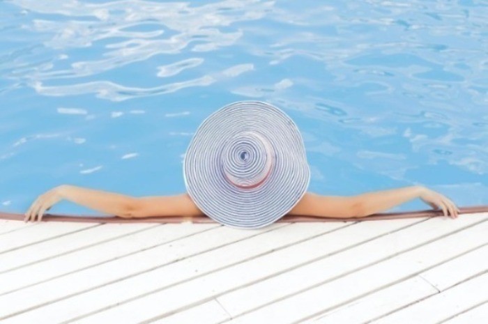 woman leaning on white concrete surface beside swimming pool during daytime photo – Free Summer Image on Unsplash