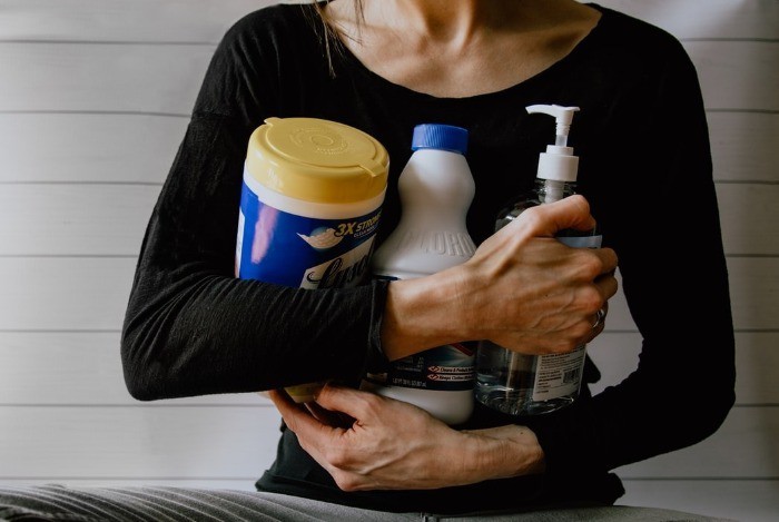 woman in black long sleeve shirt holding white and yellow plastic bottle photo – Free Hygiene Image on Unsplash