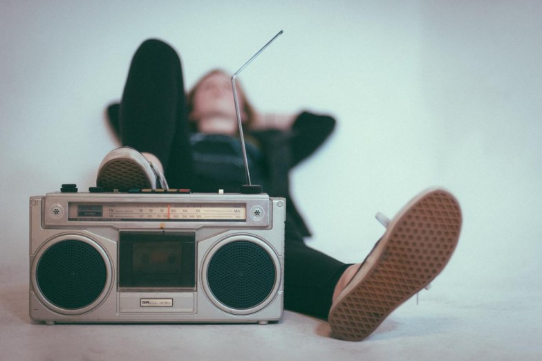 woman laying on bed near gray radio photo
