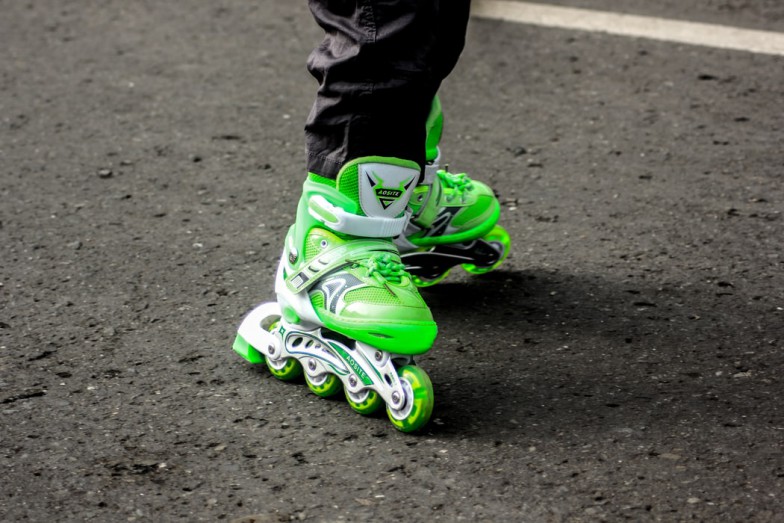 person wearing pair of green inline skates photo