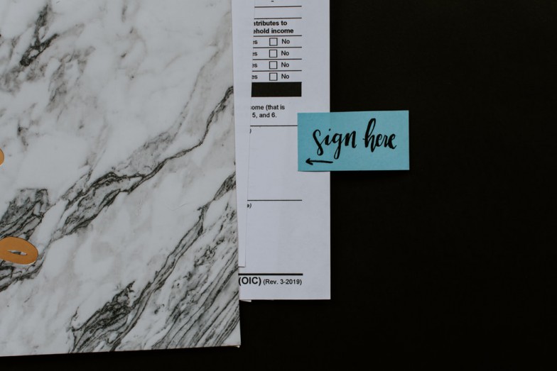 sign here sign near blank space on paper photo