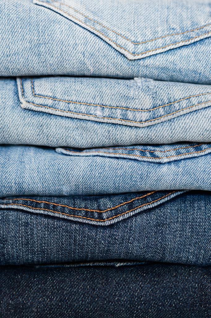 Stack of blue jeans arranged by color