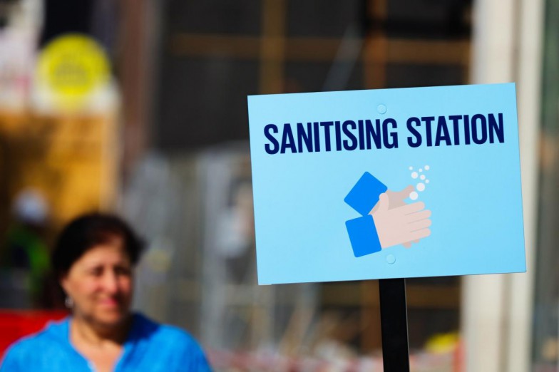 man in blue shirt holding white and black no smoking sign photo