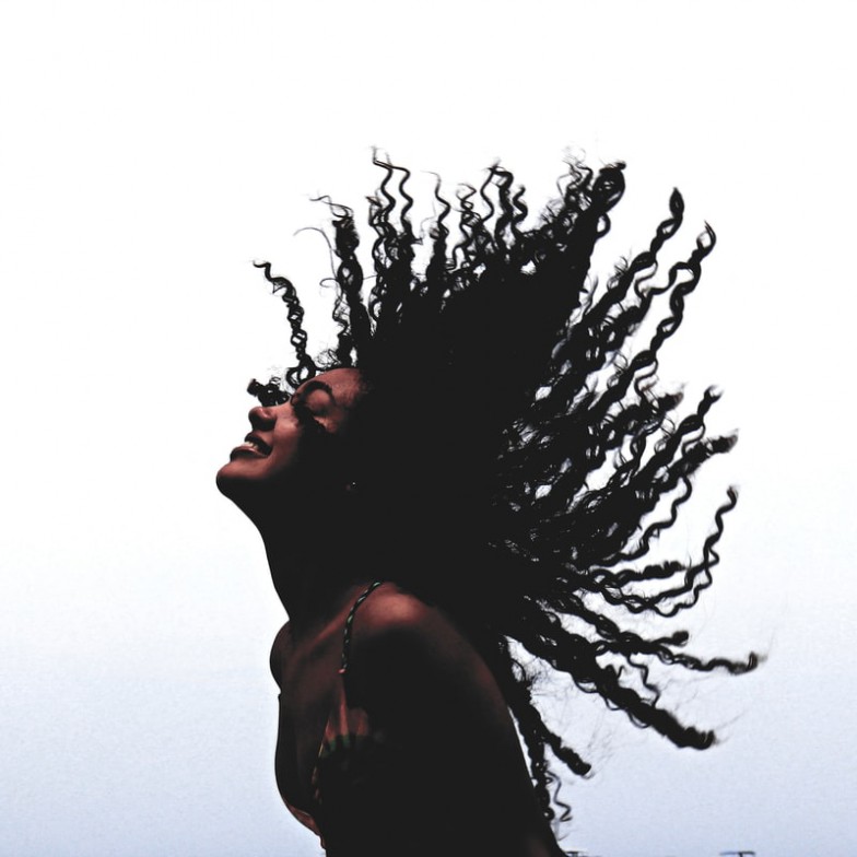 woman in black tank top standing beside leafless tree during daytime photo